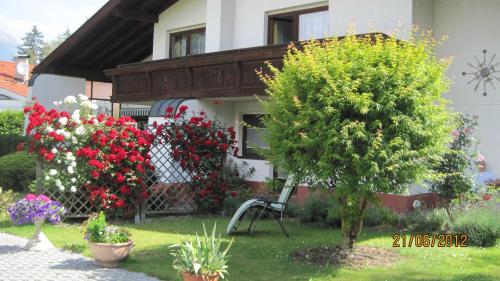 因斯布鲁克Appartements Wessely am Golfplatz Lans Innsbruck的院子里有鲜花和椅子的房子