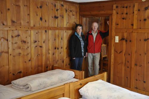 Schweizerhof的一名男子和一名女子站在带两张床的房间