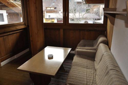 Schweizerhof的一间配有沙发、一张桌子和两个窗户的客房