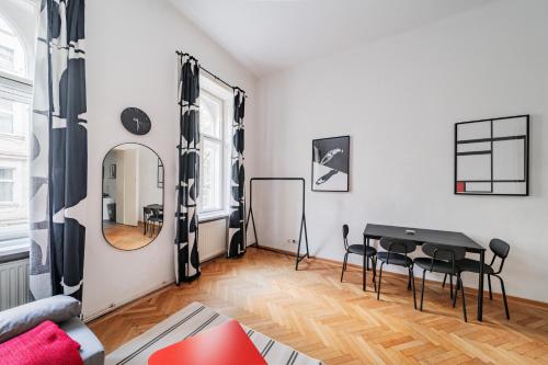 维也纳Charmante Stadtwohnung的客厅配有桌椅和镜子