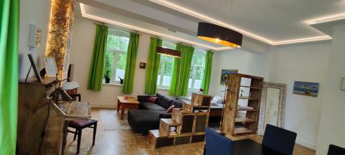 什未林Modernes Wohnen am See的客厅配有绿色窗帘和沙发