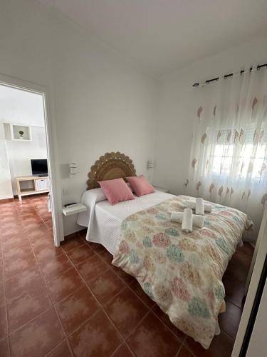 塔里法Apartamento Entre dos mares的一间卧室配有一张带粉红色枕头和镜子的床