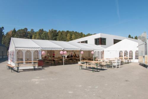 格里姆斯塔BiG Event AS的一组配有桌子和粉红色气球的白色帐篷