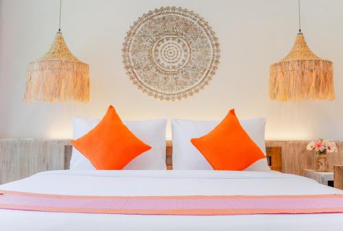 查汶LOVE beach club Koh Samui的卧室配有带橙色枕头的白色床