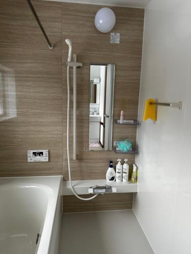 南鱼沼市Urasa Cottage @ Snow Countryside的带淋浴、盥洗盆和镜子的浴室