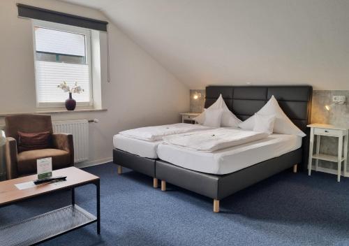 索尔陶Hotel Dat greune Eck的一间卧室配有一张大床和一把椅子