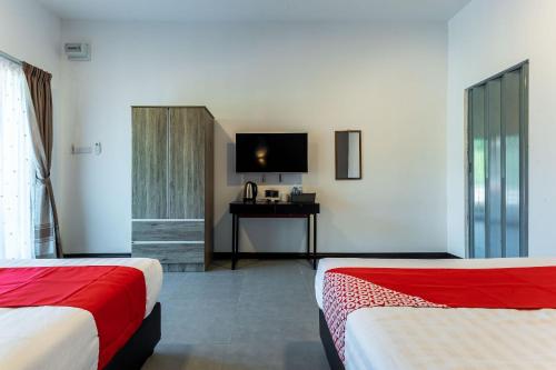 仙本那OYO 90149 Pua Family Semporna的酒店客房设有两张床和电视。