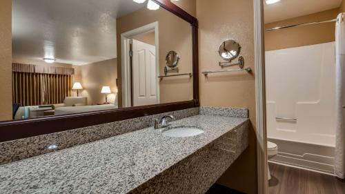 福图纳贝斯特韦斯特乡村酒店的一间带水槽和大镜子的浴室
