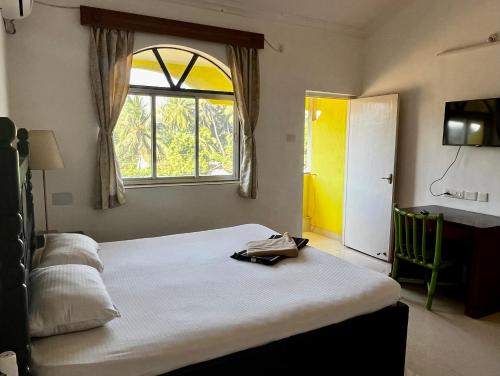 瓦尔恰Easy Living Guesthouse的一间卧室设有一张大床和一个窗户。