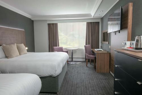 伯明翰Best Western Plough and Harrow Hotel的酒店客房设有两张床、一张桌子和一间厨房。