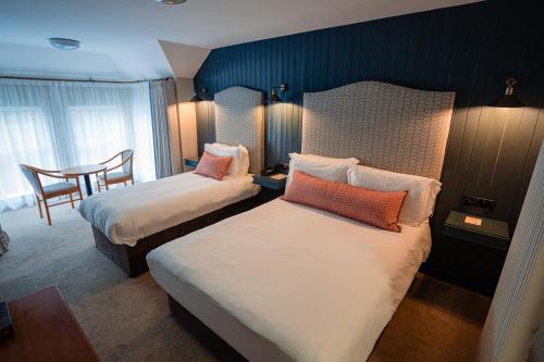 卡尔达夫McGrory's Hotel的酒店客房设有两张床和一张桌子。