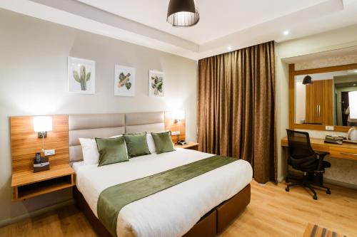 亚的斯亚贝巴君主酒店的酒店客房设有一张大床和一张书桌。