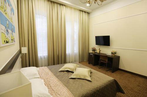 敖德萨Hotel Donald的一间卧室配有一张床、一张书桌和一台电视