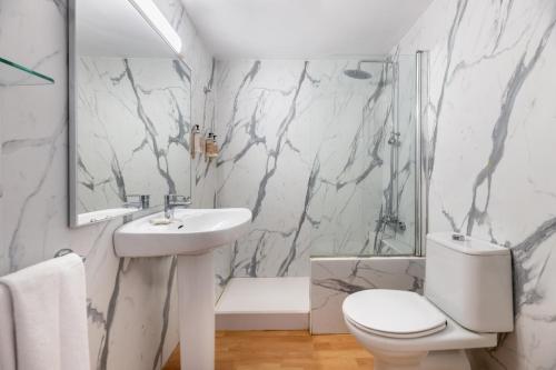 萨卡莱塔Vibra Caleta Playa Apartmentos-3SUP的白色的浴室设有水槽和卫生间。