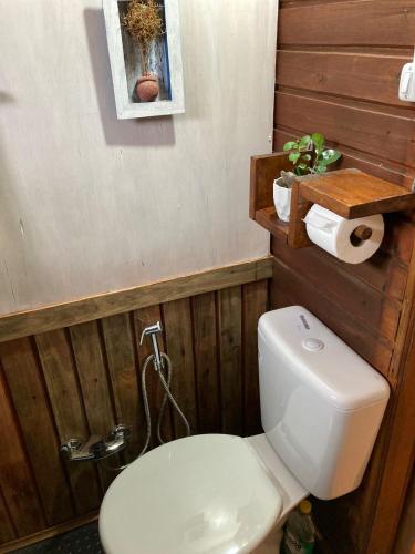 塔夸伦博La Casita的浴室设有白色卫生间和木墙