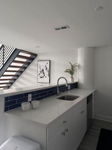 DarbyMEB Loft的白色的厨房设有水槽和楼梯