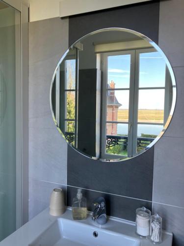 索姆河畔的圣瓦列里Chambres avec Vue的浴室设有镜子和窗户,位于水槽上