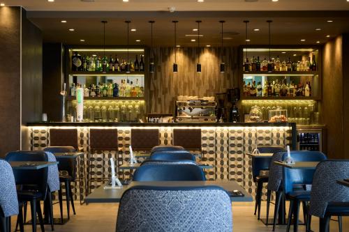 马略卡岛帕尔马加泰罗尼亚马略卡酒店的一间设有蓝色椅子的餐厅和一间酒吧