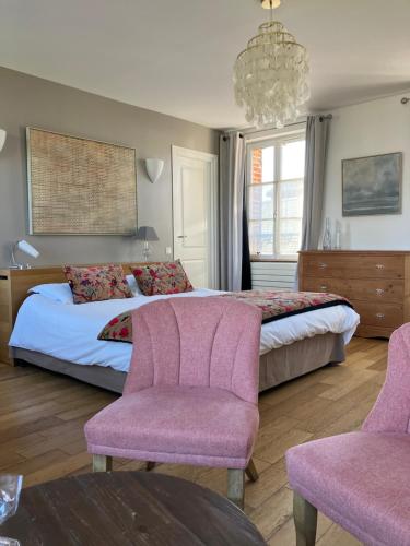 索姆河畔的圣瓦列里Chambres avec Vue的一间卧室配有一张带粉红色椅子和吊灯的床。