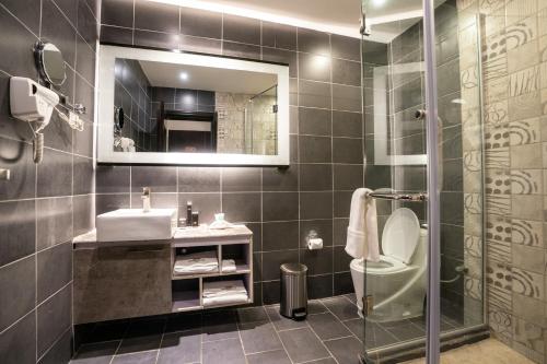 亚的斯亚贝巴君主酒店的一间带水槽、卫生间和镜子的浴室