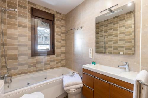 塞拉内华达BiBo Suites Sierra Nevada的带浴缸、水槽和镜子的浴室