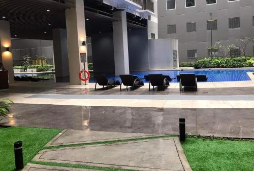 马尼拉C Place - Capsule A的酒店大堂设有椅子和游泳池