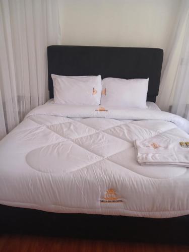 内罗毕TAWALA GARDEN HOTEL的白色的床、白色床单和枕头