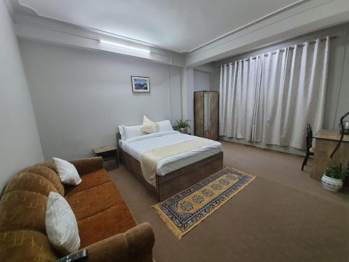甘托克Payong House的客厅配有床和沙发