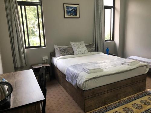 甘托克Payong House的一间卧室设有一张大床和两个窗户。