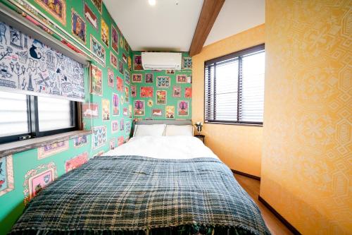 东京恵比寿広尾エリア　複数寝室トイレ　キッチン設備充実的卧室配有一张床铺,位于拥有色彩缤纷的墙壁的房间