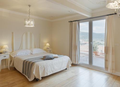 博萨Palazzo Pischedda的白色的卧室设有床和大窗户