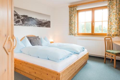 特洛普拉赫Hotel Pension Appartement Kristall的一间卧室配有一张带白色床单的木床