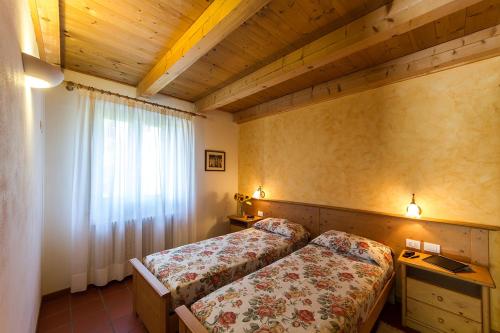 PrepottoColli di Poianis的一间卧室设有两张床,其中设有窗户。