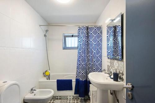 加法尼亚-达纳扎雷MAISON DE VACANCES AVEIRO的浴室配有盥洗盆、卫生间和浴缸。