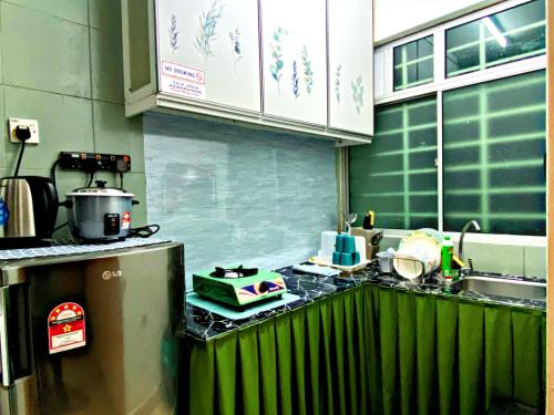 波德申Izdisa Muslim Homestay Teluk Kemang Groundfloor unit with Pool view的厨房配有带水槽和炉灶的台面