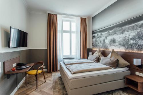 博尔库姆霍亨索伦海滩酒店的配有一张床和一张书桌的酒店客房