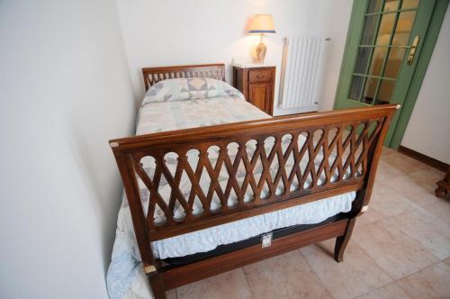 巴塔利亚泰尔梅Appartamento Colli & Terme的卧室内的木床和灯