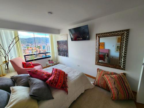 库斯科Apartamento de lujo en zona exclusiva de Cusco的一间卧室配有一张带镜子和椅子的床