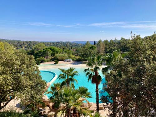 格里莫Les Restanques 3120 vue mer 3 chambres的享有棕榈树游泳池的顶部景致