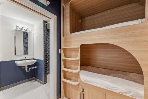 波士顿Meco Hotel的一间带双层床和水槽的小浴室