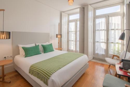 波尔图Fil's Place的一间卧室配有一张带绿色枕头的大床
