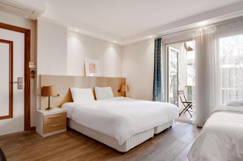 ÇekirgeYankı Otel的一间白色卧室,配有两张床和窗户