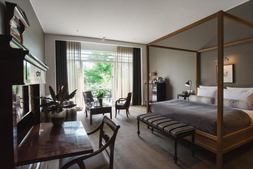 哥本哈根尼布酒店的一间卧室配有天蓬床和桌椅