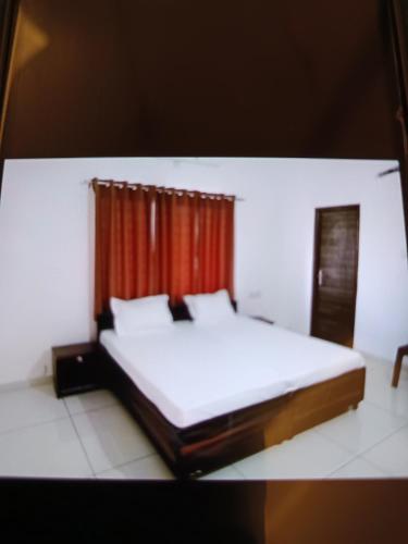 印多尔Vaatsaly home的卧室配有白色的床和红色窗帘