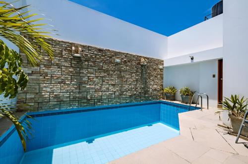 齐克拉约Hotel Casa de la Luna的一座砖墙房子中的游泳池