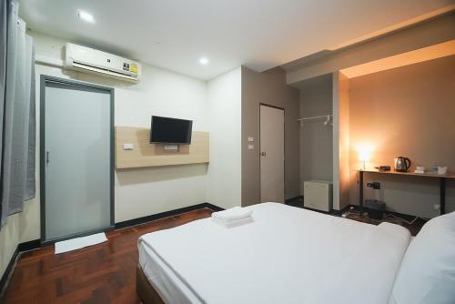 Yan NawaGO INN Silom - BTS Saint Louis โกอินน์ สีลม - สถานีรถไฟฟ้าเซนต์หลุยส์的小房间设有床铺和电视