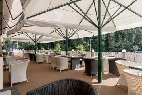 厄茨阿姆巴赫霍夫旅馆的餐厅配有桌椅,位于伞下