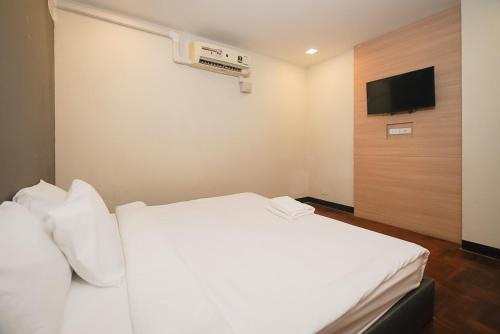 Yan NawaGO INN Silom - BTS Saint Louis โกอินน์ สีลม - สถานีรถไฟฟ้าเซนต์หลุยส์的酒店客房设有白色的床和电视。