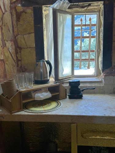 达纳DanaBlack iris house的一张桌子、咖啡壶和窗户