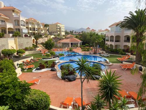 圣米格尔德阿沃纳GOLF PARK Resort的一座带游泳池、椅子和建筑的度假村